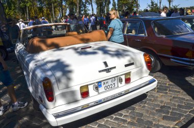 Rolls-Royce Corniche, zarif tasarımı ve güçlü performansı ile tanınan lüks İngiliz arabası. Araba beyaz, kendine özgü bir ızgarası ve kafası var.