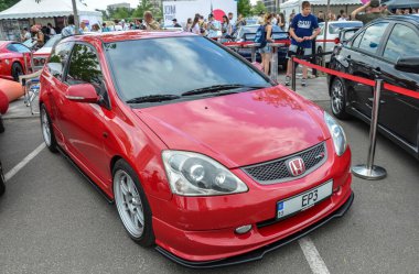 Kırmızı Honda Civic Type R kendine özgü vücut kiti ve agresif stili ve güçlü motoru ile bilinen geniş arka kanadı olan popüler bir performans arabası.