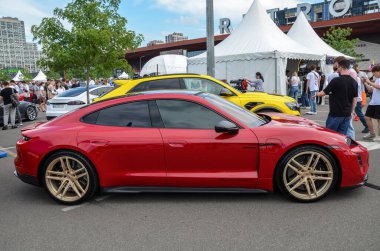 Kırmızı Porsche Taycan, yüksek performanslı elektrikli spor araba, lüks, hız ve sürdürülebilirliği birleştiriyor. 