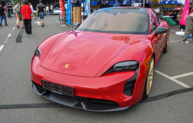 Kırmızı Porsche Taycan, yüksek performanslı elektrikli spor araba, lüks, hız ve sürdürülebilirliği birleştiriyor. 