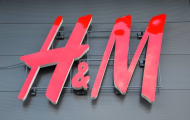 Moda ve markalaşma açısından modern gri arka plana karşı H & M işareti. Çarpıcı kırmızı renk marka kimliğini vurgular ve dikkat çeker