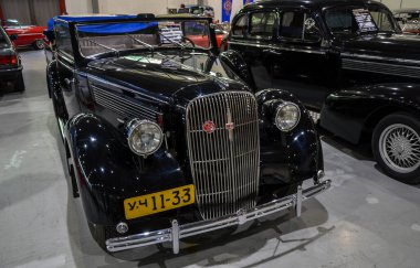 Siyah 1936 Opel Super 6, genellikle üstü açık veya sedan gövde stillerinde görülen klasik tasarımıyla bilinen Avrupa otomobillerinin altın çağının sembolüdür.