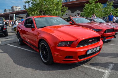 Kırmızı Ford Mustang, klasik Amerikan kaslı arabası. Bu beşinci nesil model, saldırgan stili ve modern özellikleriyle, Mustang 'in güç mirasını sürdürüyor.