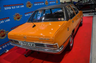 Orange Opel Rekord, 1970 'lerin klasik arabası. Gösterişli tasarım ve canlı renk onun eski cazibesini vurguluyor.