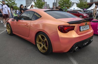 Modifiye edilmiş Subaru BRZ. Eşsiz turuncu boya ve altın tekerlekleri var. Araba, düşük süspansiyon ve ön ayırıcı ile özelleştirildi.