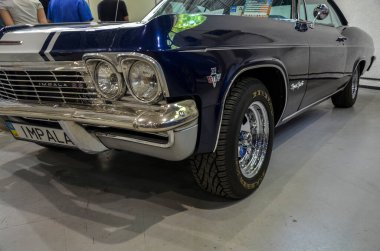 Klasik Chevrolet Impala SS ön detayları ön farlar ve ızgara ile birlikte kaputta koşan belirgin beyaz yarış şeridiyle birlikte gösteriyor. 