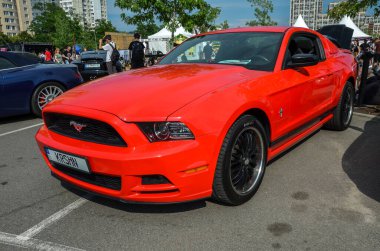 Kırmızı Ford Mustang, güçlü motoru, heyecan verici performansı ve ayırt edici tasarımıyla bilinen ikonik Amerikan kaslı arabası.