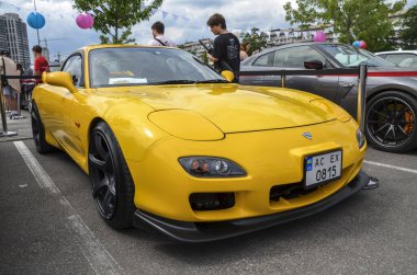Sarı Mazda RX-7 FD: Çok rağbet gören ve koleksiyon yapılabilen bir Japon spor arabası. Benzersiz tasarımı ve performansı onu modern bir klasik yapıyor.