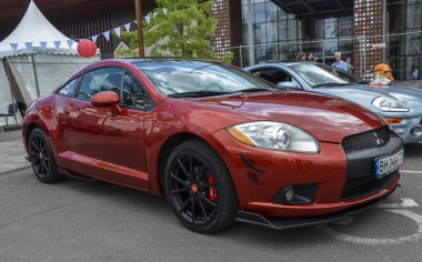 Kırmızı araba 2010 Mitsubishi Eclipse, şık tasarımı ve performans kabiliyeti ile bilinen spor coupe