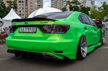 Canlı yeşil Lexus LS (XF40) sedan, özel modifikasyonlar, düşük süspansiyon ve büyük gümüş alaşımlı tekerlekler, bir araba fuarında park