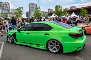 Canlı yeşil Lexus LS (XF40) sedan, özel modifikasyonlar, düşük süspansiyon ve büyük gümüş alaşımlı tekerlekler, bir araba fuarında park