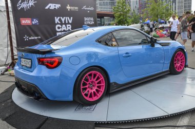 Göz alıcı pembe jantları olan parlak mavi spor araba Subaru BRZ. Çevik ve şık tasarımı ile ünlüdür. Araba etkinlikleri ve fotoğraf çekimleri için mükemmel.