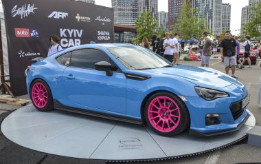 Göz alıcı pembe jantları olan parlak mavi spor araba Subaru BRZ. Çevik ve şık tasarımı ile ünlüdür. Araba etkinlikleri ve fotoğraf çekimleri için mükemmel.