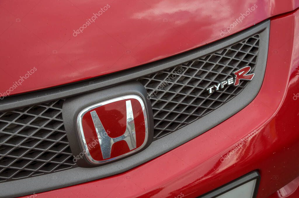Iconic Honda logo, emblazoned on red Honda Civic Type R grille, is symbol of performance and driving passion