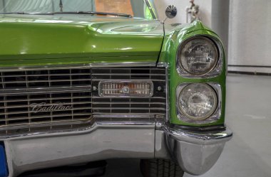 Klasik Cadillac Deville tarzı, ön ızgaraya yakın çekim, farlar, ve klasik lüks bir arabanın tamponu.