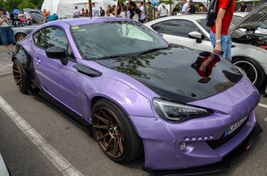 Modifiye spor araba mor Subaru BRZ açık hava araba etkinliği sırasında siyah kaput, geniş gövde kiti ve bronz tekerlekler
