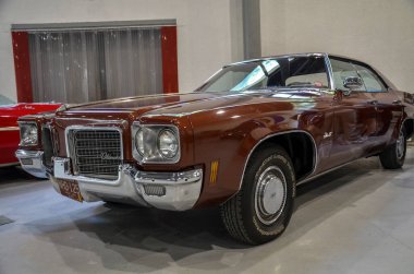 Klasik kahverengi Oldsmobile Delta 88 krom aksanını, ızgara vintage çekiciliğini ve Amerikan otomotiv tasarımı için nostalji duygusunu ortaya koyuyor.