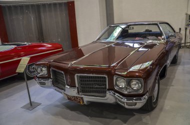 Klasik kahverengi Oldsmobile Delta 88 krom aksanını, ızgara vintage çekiciliğini ve Amerikan otomotiv tasarımı için nostalji duygusunu ortaya koyuyor.