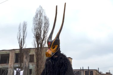 Shrovetide kutlamaları sırasında şehir sokak festivali ortamında uzun boynuzlu, eşsiz, sanatsal bir maske takan çarpıcı bir şahsiyet.