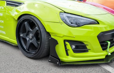 Kireç yeşili Subaru BRZ spor arabası, siyah tekerlekler, geniş çamurluklar, ve ön tampon ve perçin kaplı vücut kiti onu cesur ve göz alıcı yapıyor.