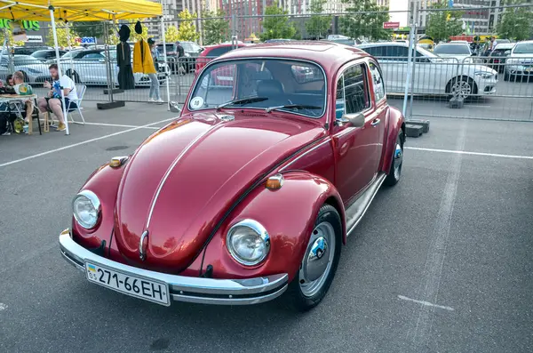 Kırmızı Volkswagen Beetle ikonik küçük aile arabası, otomotiv tarihinin en tanınmış arabalarından biri, kendine özgü yuvarlak şekli ve arka motoru ile tanınıyor.