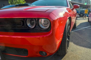Kırmızı Dodge Challenger 'ın önünde ikonik yuvarlak farlar, agresif tasarım ve karartılmış ızgara
