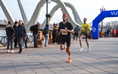 Seyircilerin tanık olduğu canlı koşu yarışında katılımcılar yarışıyor. Sahne, olayın enerjisini ve koşucuların nişanını yakalıyor.