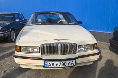 Bej 1988 Buick Regal, orta boy lüks sedan, önden çekişli ve gösterişli tasarımı klasik bir konfor arayanlar için çekici.