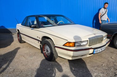 Bej 1988 Buick Regal, orta boy lüks sedan, önden çekişli ve gösterişli tasarımı klasik bir konfor arayanlar için çekici.