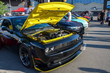 Bu Dodge Challenger, klasik kaslı arabasının cazibesine benzersiz ve modern bir dokunuş ekleyerek, çarpıcı sarı aksanlı özel siyah dış görünüşüyle öne çıkıyor.