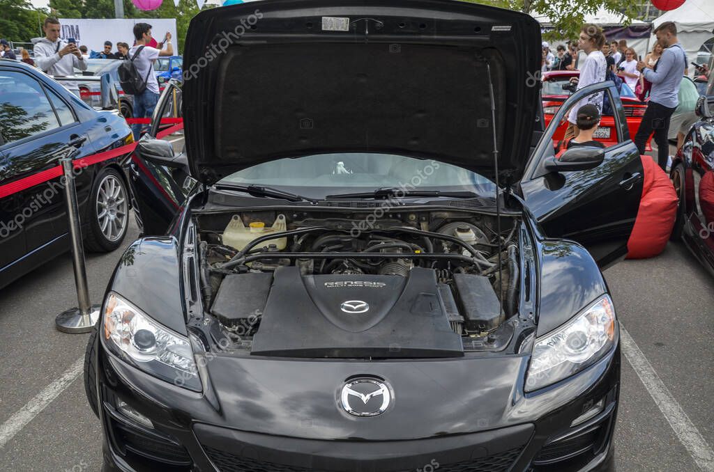 Black Mazda RX-8 with its hood open, displaying the engine bay marked 