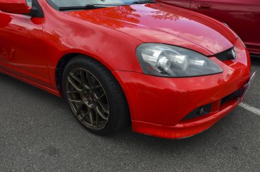 Sportif coupe kırmızı Acura RSX 'in (Honda Integra Type R) önünde parlak tasarımı ve bronz tekerlekleri sergilenmektedir.