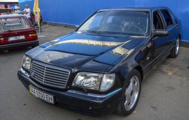 Siyah Mercedes-Benz W140 S-Class, gelişmiş teknolojisi, sağlam mühendisliği ve zamansız tasarımı ile ünlü lüks bir sedan.