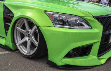 Parlak yeşil Lexus LS (XF40) ve özel geniş gövde kiti ile gümüş artçı çark açık hava park edilir