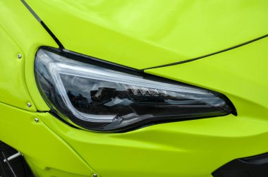 Canlı yeşil Subaru BRZ 'nin parlak modern farları. Tasarım net ve siyah elementleri keskin çizgiler ve görünür vidalar ile harmanlayarak araçların dış stil dokunuş ekler