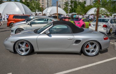 Gümüş renkli, şık spor araba Porsche Boxster üstü açık, üstü açık, siyah, yumuşak tavanlı. Hız, zarafet ve zanaatkarlık barındırıyor.