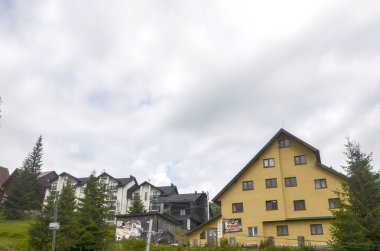 Dragobrat kayak merkezinin kır evi gökyüzünün altında, yeşilliklerin arasına kurulmuş ve ağaçlarla çevrili. Karpat Dağları, Ukrayna