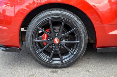 Siyah BBS jant ve kırmızı Brembo fren kalibreli arabanın arka tekerleğinin yakın çekimi. Aracın kırmızı vücudu spor ve yüksek performanslı estetiğini geliştirir.