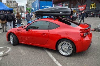 Spor kırmızısı Compact Coupe Subaru BRZ. Piyasa sonrası gümüş alaşımlı tekerleklerle donatılmıştır. Çok dilli tasarımıyla şık ve agresif duruşunu geliştirmiştir.
