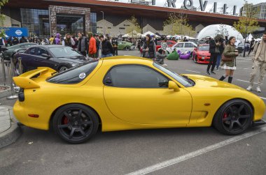 Parlak sarı Mazda RX-7 Japon spor arabalarının altın çağını simgeliyor. Harmanlama tarzı, hızı ve yenilikleri unutulmaz bir tasarım haline getiriyor.