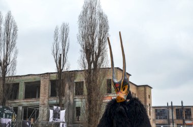Uzun, dekoratif maskelerin yer aldığı özenle hazırlanmış geleneksel kostümlü kişiler, açık hava kültür festivaline katılıyorlar.