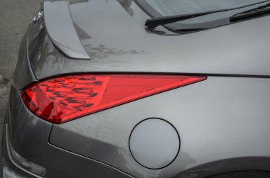 Gri Nissan arabasının arkasında, gösterişli arka lambası, yakıt başlığı ve arka spoyler var.