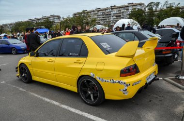 Çarpıcı sarı, yüksek performanslı akortçu Mitsubishi Lancer Evolution Turbo şarjlı gücü ve dört çekişli performansıyla bilinen efsanevi Japon spor sedanı