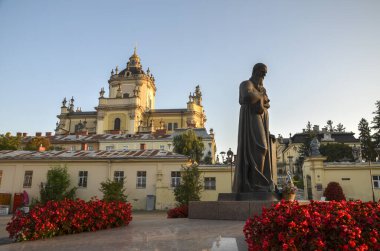 Andrey Sheptytsky anıtı Lviv 'de büyük bir Aziz George Katedrali' nin önünde duruyor. Önplanda kırmızı çiçekler açar açık mavi bir gökyüzünün altında