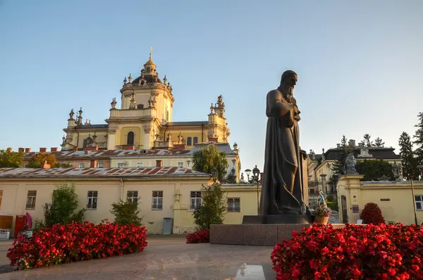 Andrey Sheptytsky anıtı Lviv 'de büyük bir Aziz George Katedrali' nin önünde duruyor. Önplanda kırmızı çiçekler açar açık mavi bir gökyüzünün altında