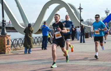 Bir maratonda yarışan bir grup sporcu, halka açık bir etkinlikte bir rekabet ve atletizm ruhu sergilediler.