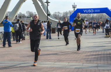 Bir maratonda yarışan bir grup sporcu, halka açık bir etkinlikte bir rekabet ve atletizm ruhu sergilediler.