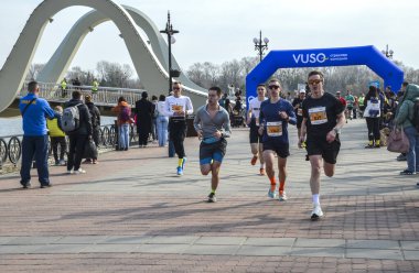 Bir maratonda yarışan bir grup sporcu, halka açık bir etkinlikte bir rekabet ve atletizm ruhu sergilediler.