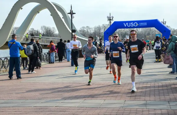 Bir maratonda yarışan bir grup sporcu, halka açık bir etkinlikte bir rekabet ve atletizm ruhu sergilediler.