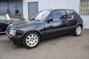 Klasik siyah Peugeot 205 kompakt ve sportif hatchback. Çevik ve zamansız tasarımı ile bilinir.